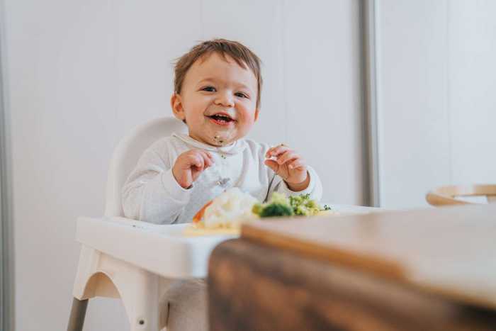 Baby in high chair being fed