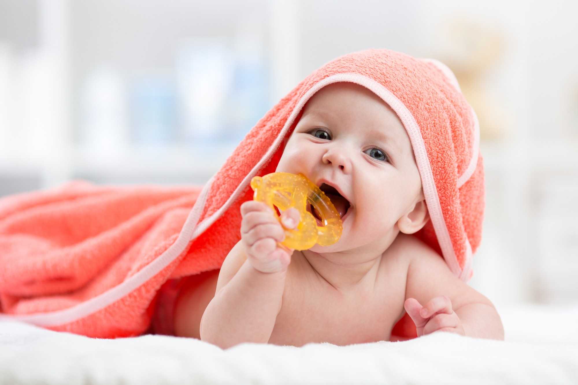 Baby in towel with teething ring
