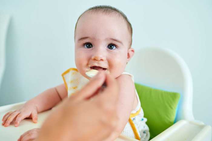 Baby in Highchair Eating with Hands