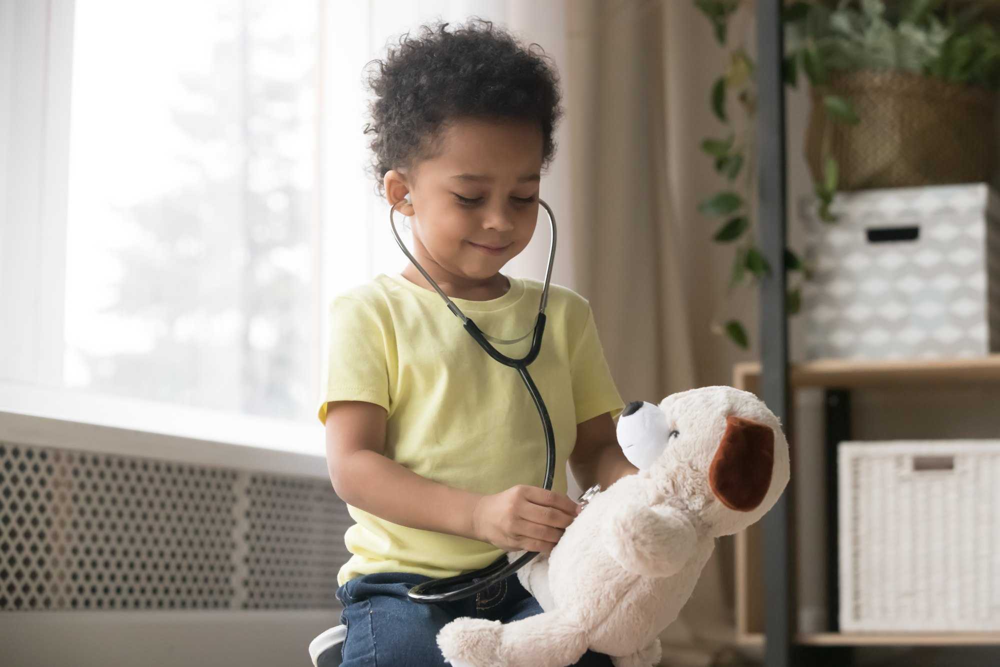 Young boy using stethoscope on a toy bear