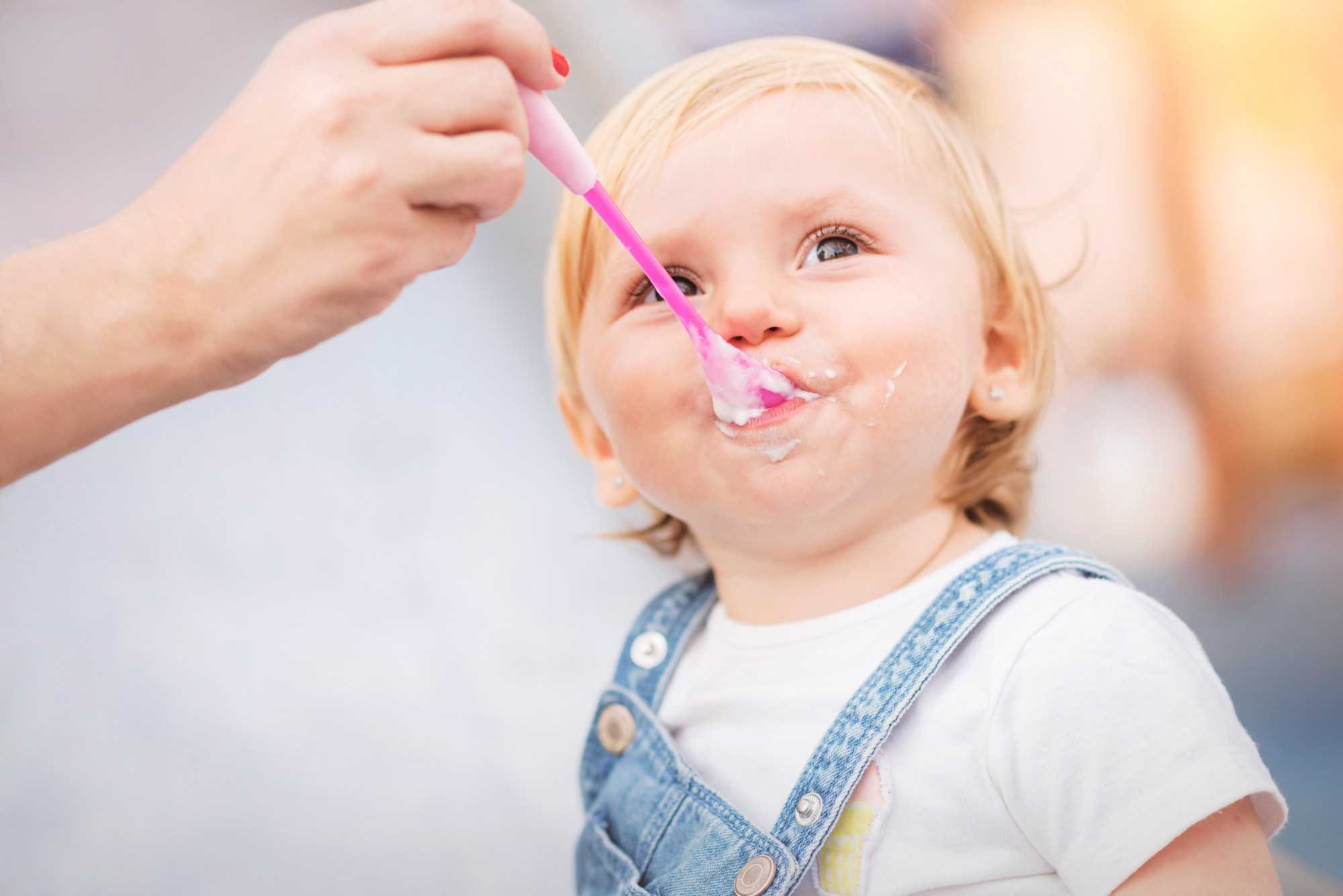 Child eating yogurt from a spoon